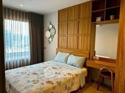 Cozy bedroom with wooden accents and natural light, featuring a stylish headboard and elegant decor.