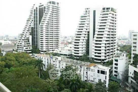 Stunning view of modern high-rise buildings surrounded by lush greenery in an urban setting.