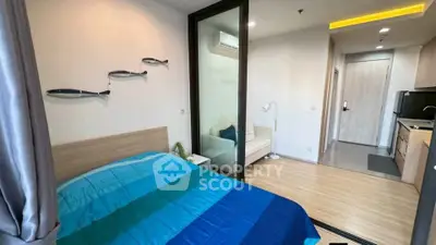 Modern studio apartment with cozy bedroom and compact kitchen layout.