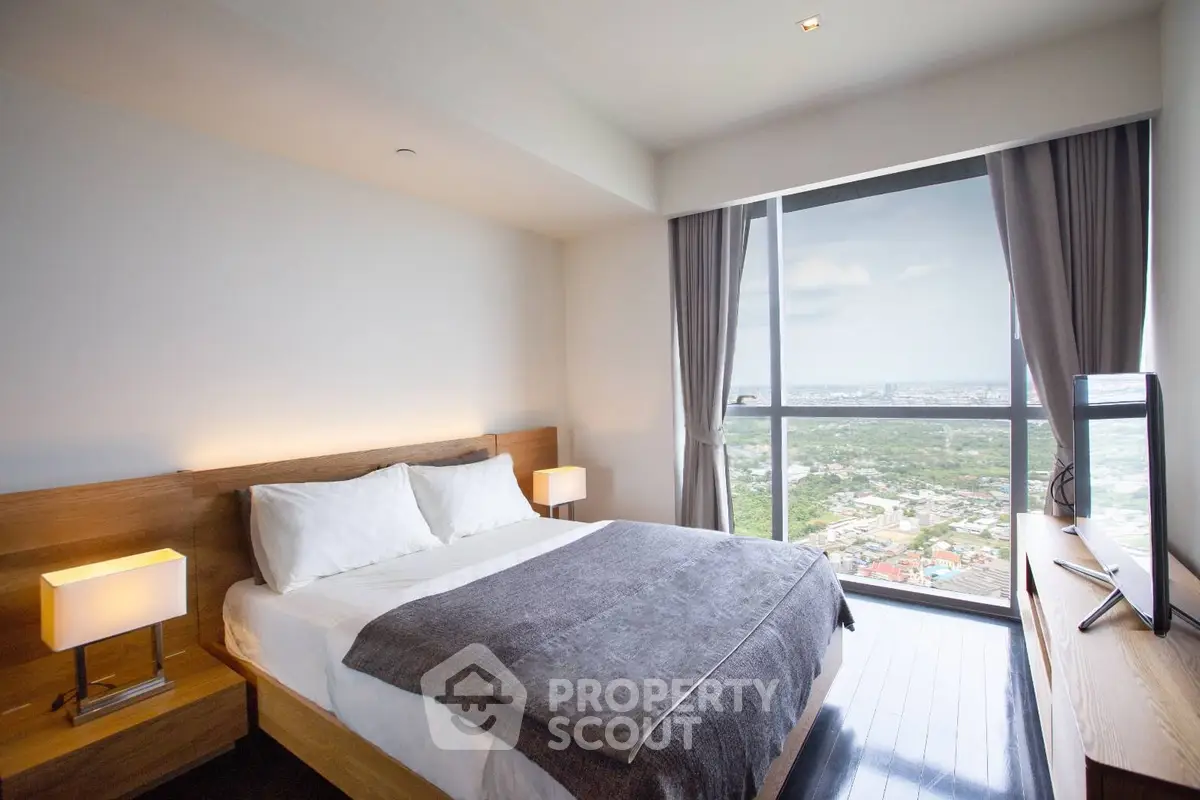 Modern bedroom with large window offering stunning city view