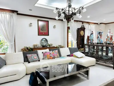 Elegant living room with plush white sofa, ornate decor, and large windows for natural light.