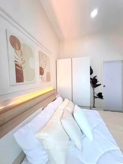 Elegant bedroom with modern decor and soft lighting, featuring a cozy bed and stylish artwork.
