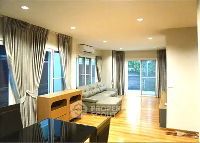 Spacious living room with modern decor and large windows for natural light.