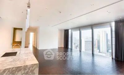 Luxurious open-plan living room with stunning city skyline view and marble kitchen island.