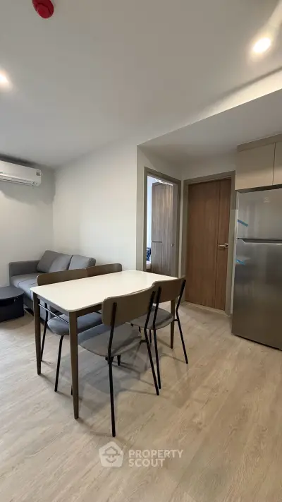 Modern living room with dining area and sleek furniture in a cozy apartment.