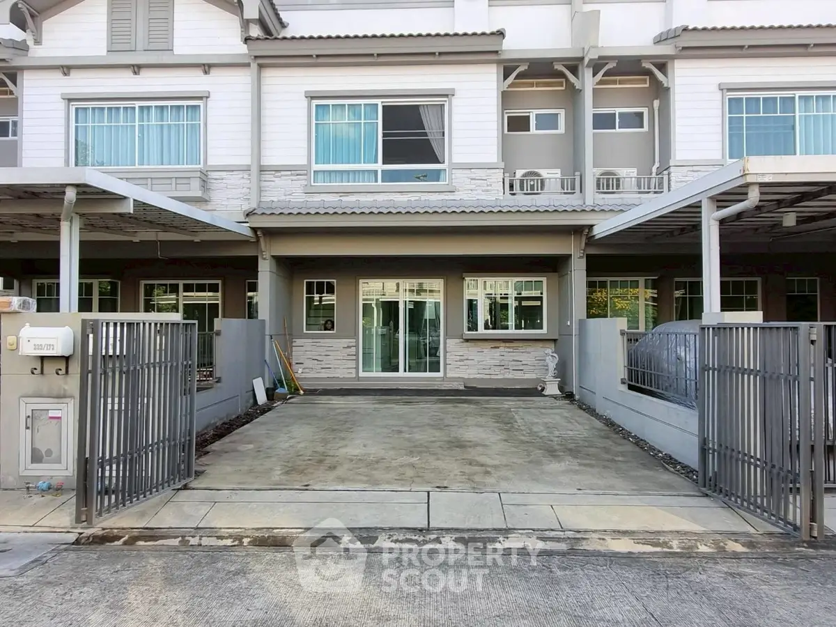 Modern townhouse with spacious driveway and gated entrance in a quiet neighborhood.