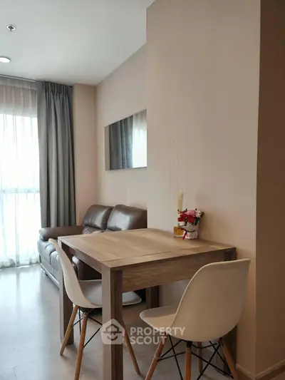 Modern living room with cozy seating and dining area, featuring elegant decor and natural light.
