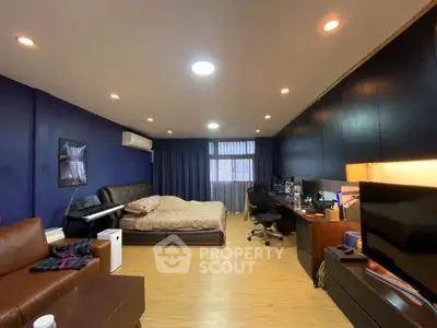 Spacious bedroom with modern decor and work area, perfect for comfort and productivity.