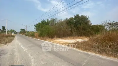 Vacant land plot with road access and lush greenery, ideal for development opportunities.