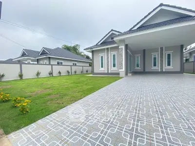 Modern single-story home with spacious driveway and lush green lawn