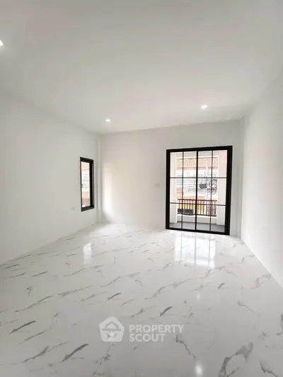 Spacious modern living room with marble flooring and large windows for natural light.