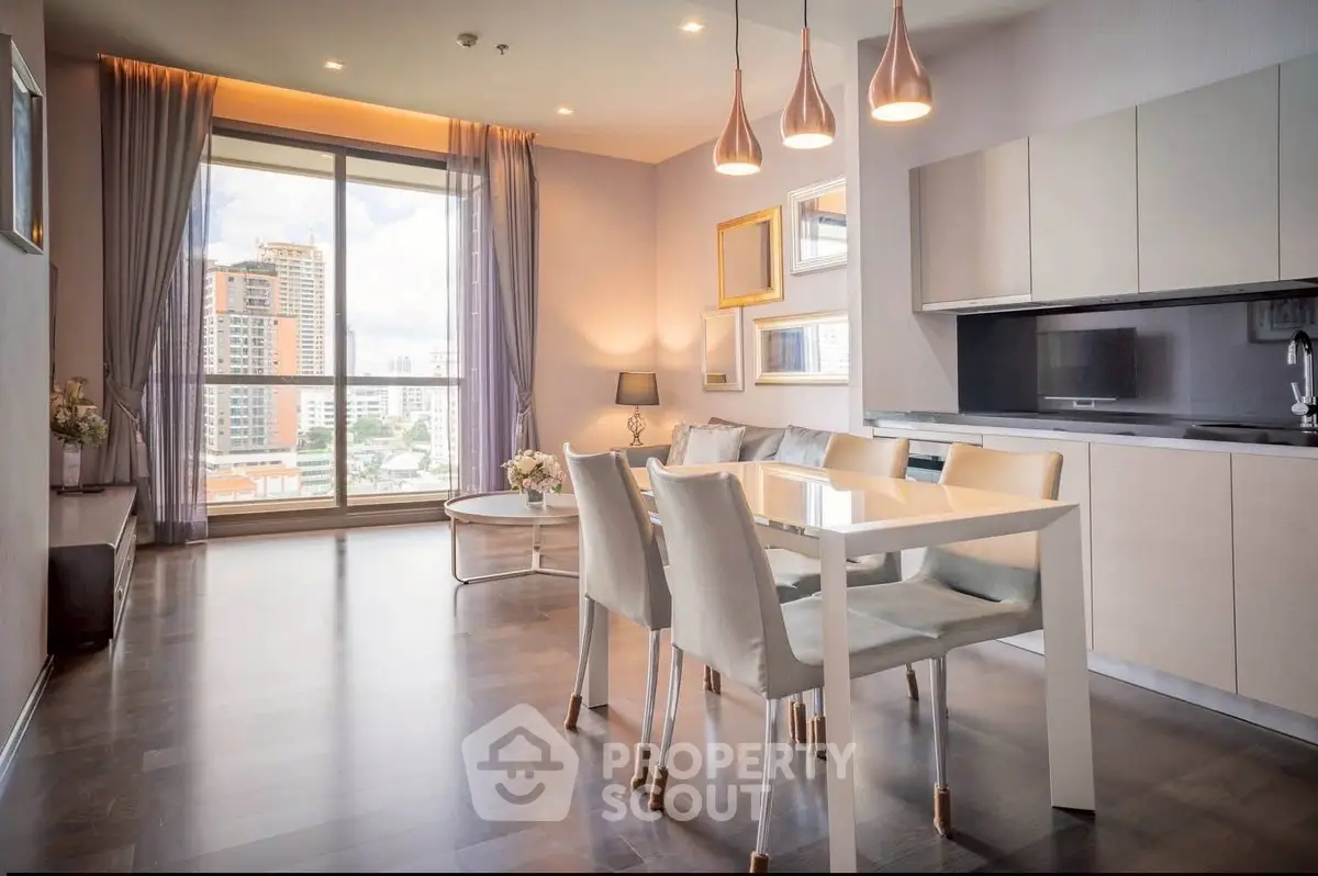 Modern open-layout living room with dining area and city view, featuring elegant lighting and contemporary decor.