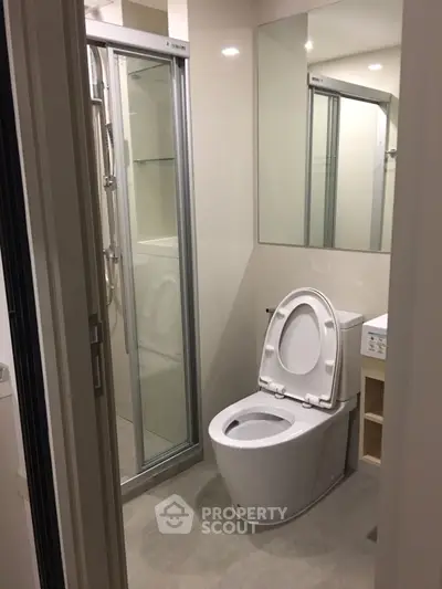 Modern bathroom with sleek shower and toilet in compact design.