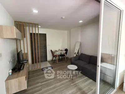 Modern living room with sleek furniture and open layout, featuring a cozy dining area and stylish decor.