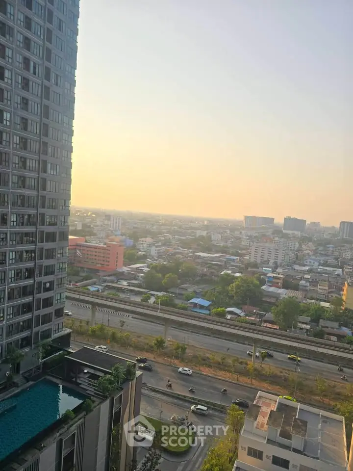 Stunning cityscape view from high-rise building with pool and sunset horizon.