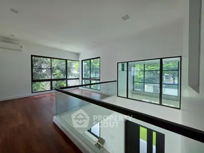 Spacious modern interior with large windows and wooden flooring, perfect for natural light lovers.
