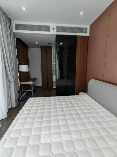 Modern bedroom with stylish decor and large wardrobe in a luxury apartment.