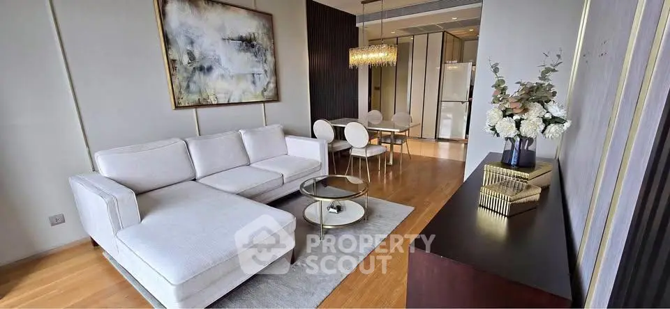 Luxurious modern living room with elegant decor and open dining area, featuring stylish furniture and chic lighting.