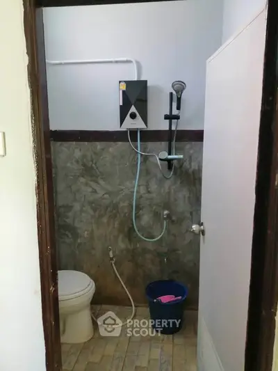 Compact bathroom with modern shower and toilet in minimalist design.