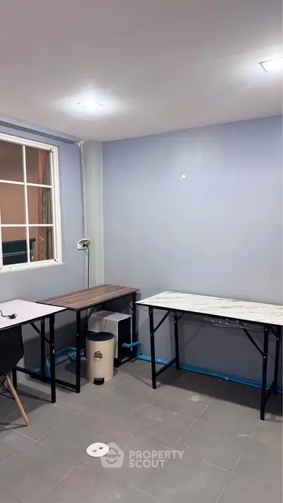 Modern study room with sleek desks and large window for natural light.