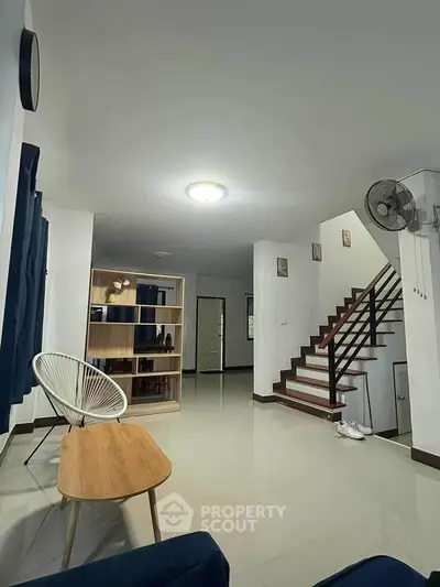 Spacious modern living room with stylish furniture and staircase