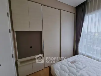 Modern bedroom with built-in wardrobe and large window offering city view