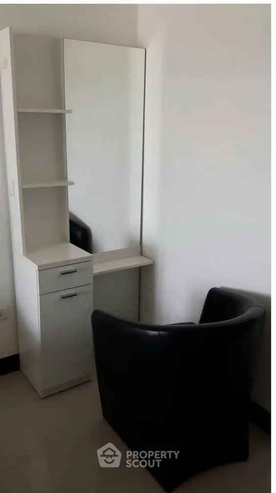 Modern minimalist corner with sleek chair and mirror in a stylish apartment.