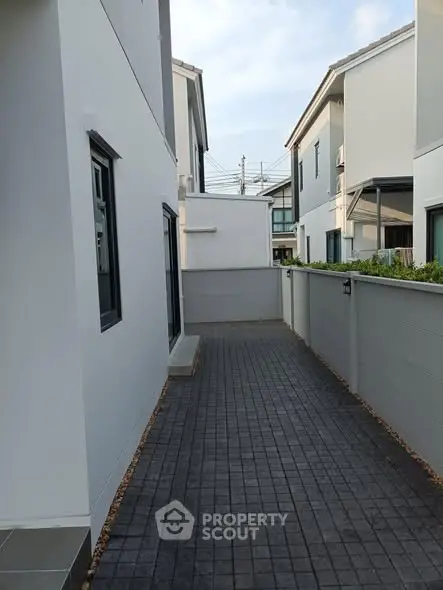 Modern townhouse exterior with paved walkway and clean design