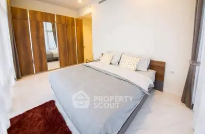 Spacious modern bedroom with elegant wooden wardrobe and cozy bed setup.