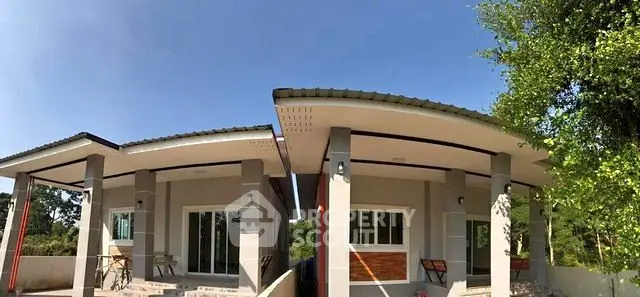 Modern twin houses with sleek design and lush greenery surroundings.