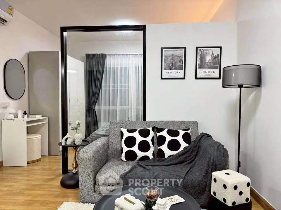 Stylish modern living room with cozy gray sofa and chic decor accents.