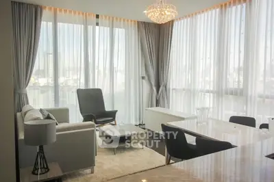Luxurious modern living room with elegant decor and large windows offering stunning city views.