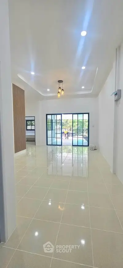 Spacious modern living room with large windows and glossy tiled floors