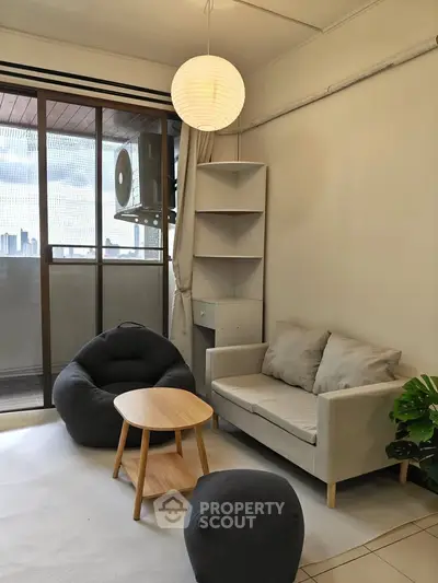Cozy living room with modern furniture and city view balcony, perfect for urban living.