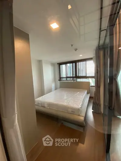 Modern bedroom with large windows and natural light in a stylish apartment.