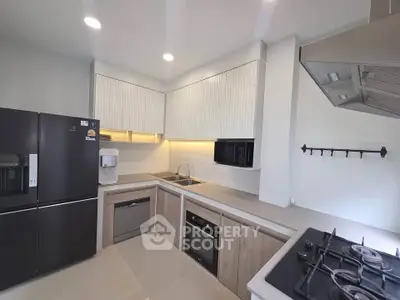 Modern kitchen with sleek appliances and open layout, featuring gas stove and ample storage.
