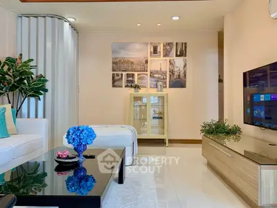 Modern living room with sleek decor, large TV, and stylish furniture, perfect for relaxation and entertainment.