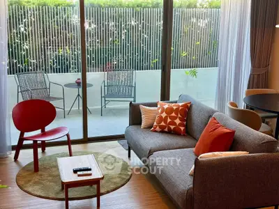 Stylish living room with modern furniture and access to a private balcony, perfect for relaxation.