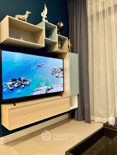 Modern living room with stylish TV unit and decorative shelving, featuring elegant decor and a serene ambiance.