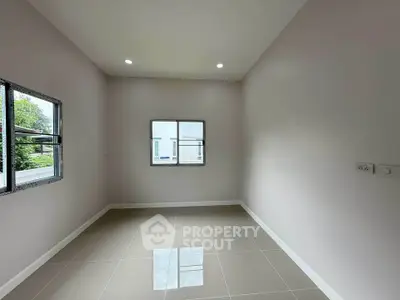 Spacious empty room with tiled floor and large windows, perfect for customization.