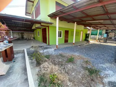 Charming green exterior house with spacious carport and outdoor area, perfect for family living.