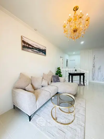 Elegant living room with plush sofa and chandelier in modern home