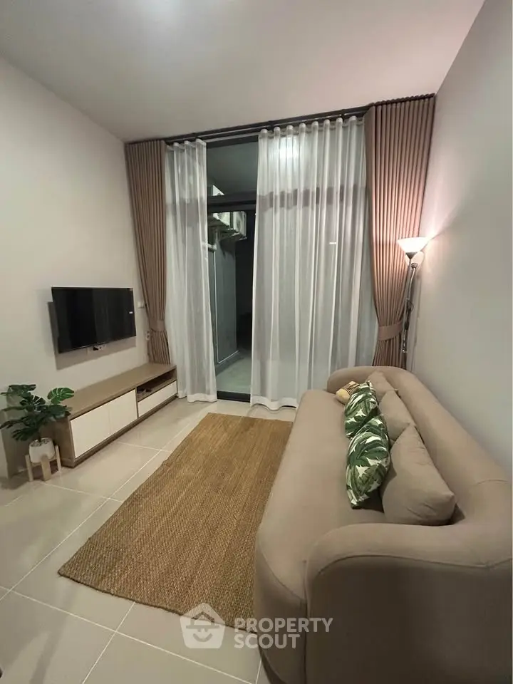 Cozy modern living room with stylish sofa, TV, and elegant curtains in a chic apartment.