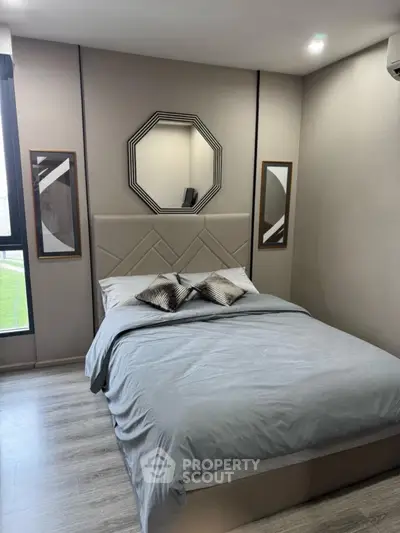 Modern bedroom with stylish decor and large windows offering natural light.