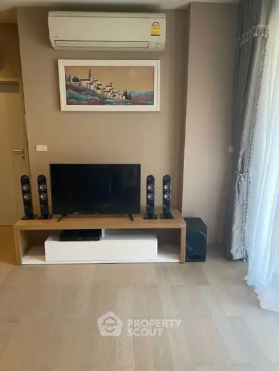 Modern living room with TV, sound system, and air conditioning unit.