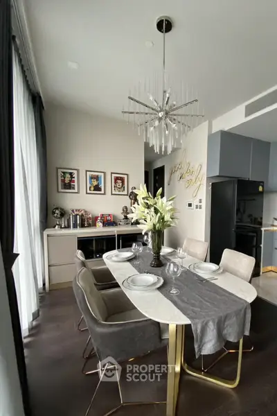 Elegant dining area with modern chandelier and stylish decor in a contemporary apartment.