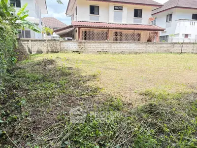 Spacious backyard with lush greenery and view of neighboring houses, perfect for outdoor activities.