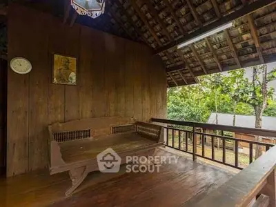 Charming rustic wooden balcony with traditional decor and lush garden view.