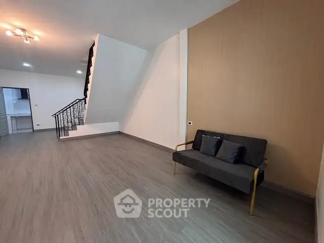 Spacious modern living room with sleek flooring and stylish staircase