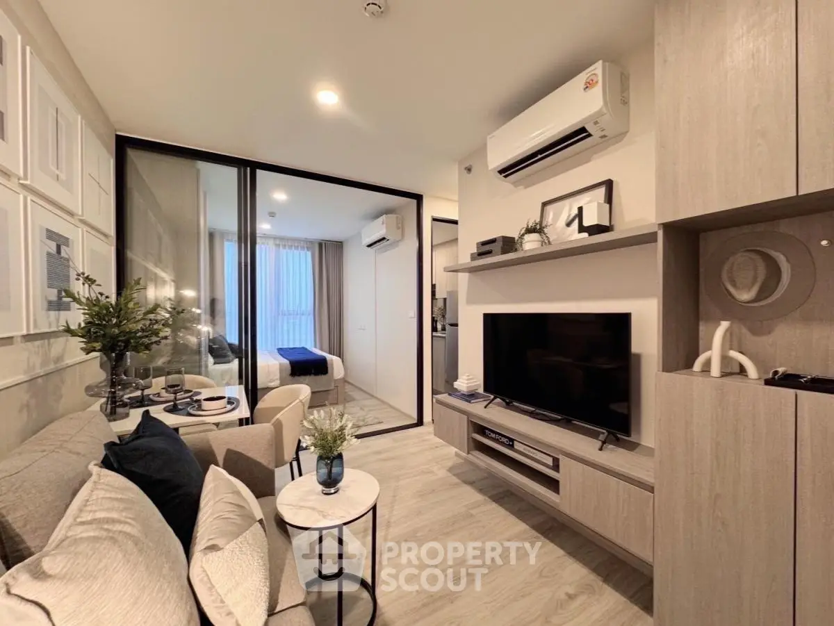 Modern living room with stylish decor and open layout leading to cozy bedroom